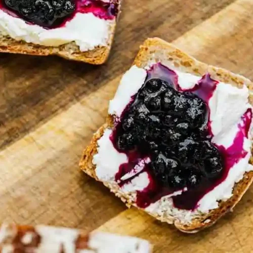 Baked blueberry cream cheese french toast casserole topped with sweet berry compote