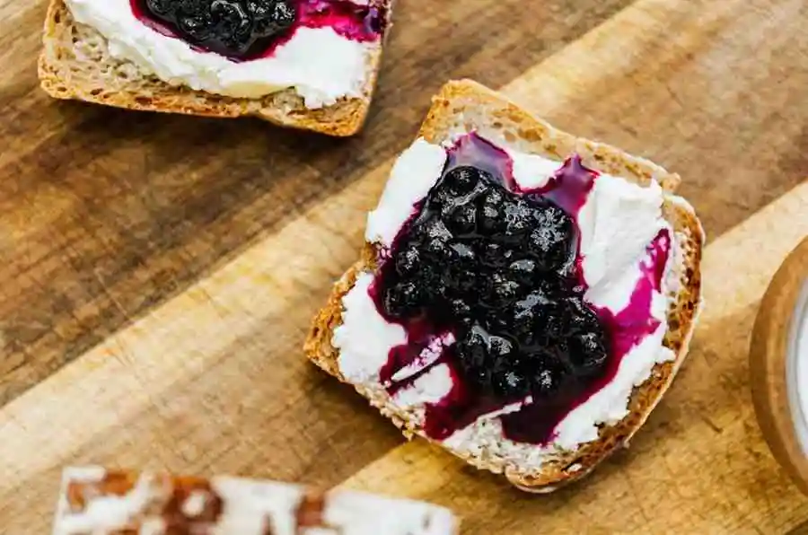 Baked blueberry cream cheese french toast casserole topped with sweet berry compote