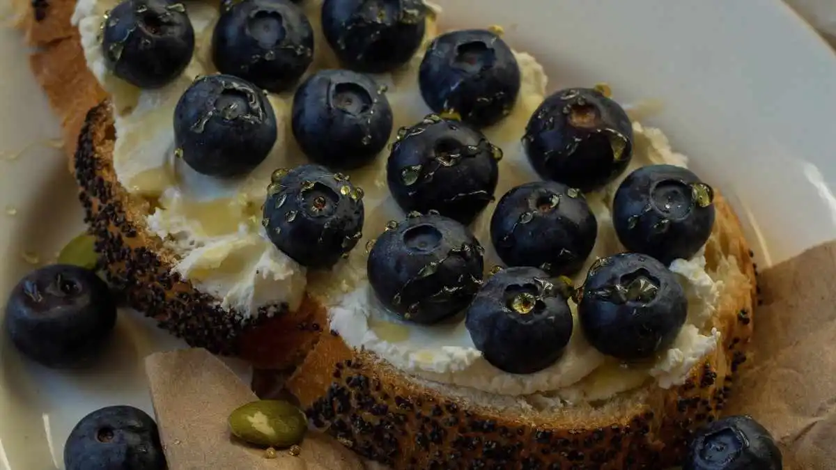Blueberry and cream cheese french toast casserole slice topped with fresh berries