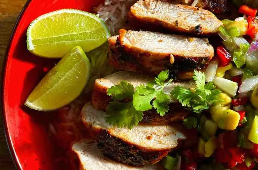 Served chicken burrito bowl topped with fresh lime cilantro and avocado