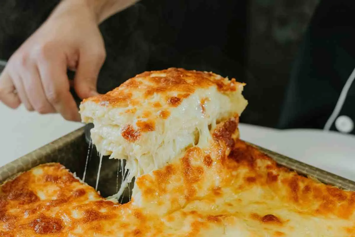 Lifting a cheesy slice of cowboy casserole with potatoes