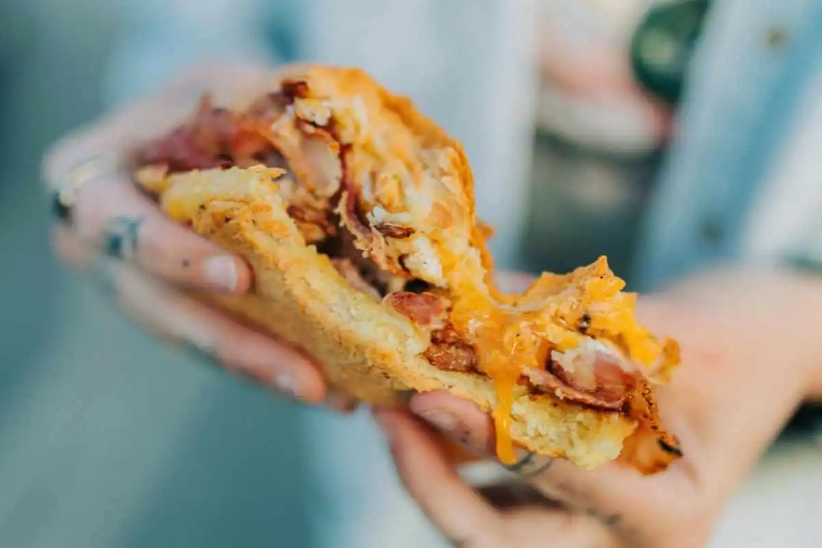 Holding a cheesy bacon egg and cheese breakfast slider