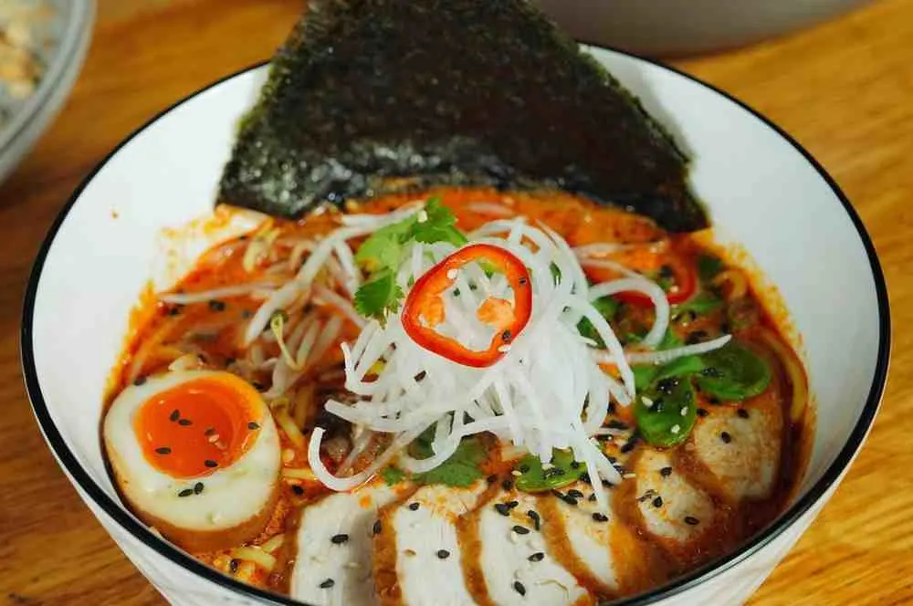 Homemade spicy chicken ramen bowl with egg, nori, and fresh green onions