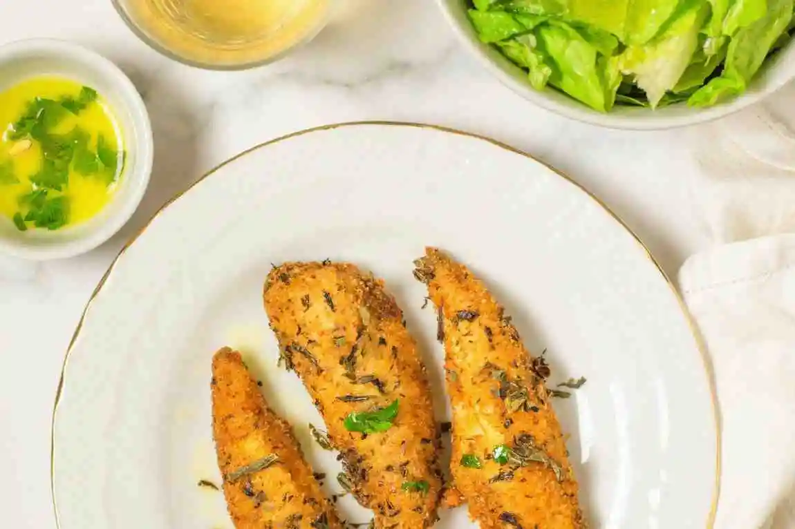 Raw chicken tenders coated in Greek yogurt and lemon herb marinade