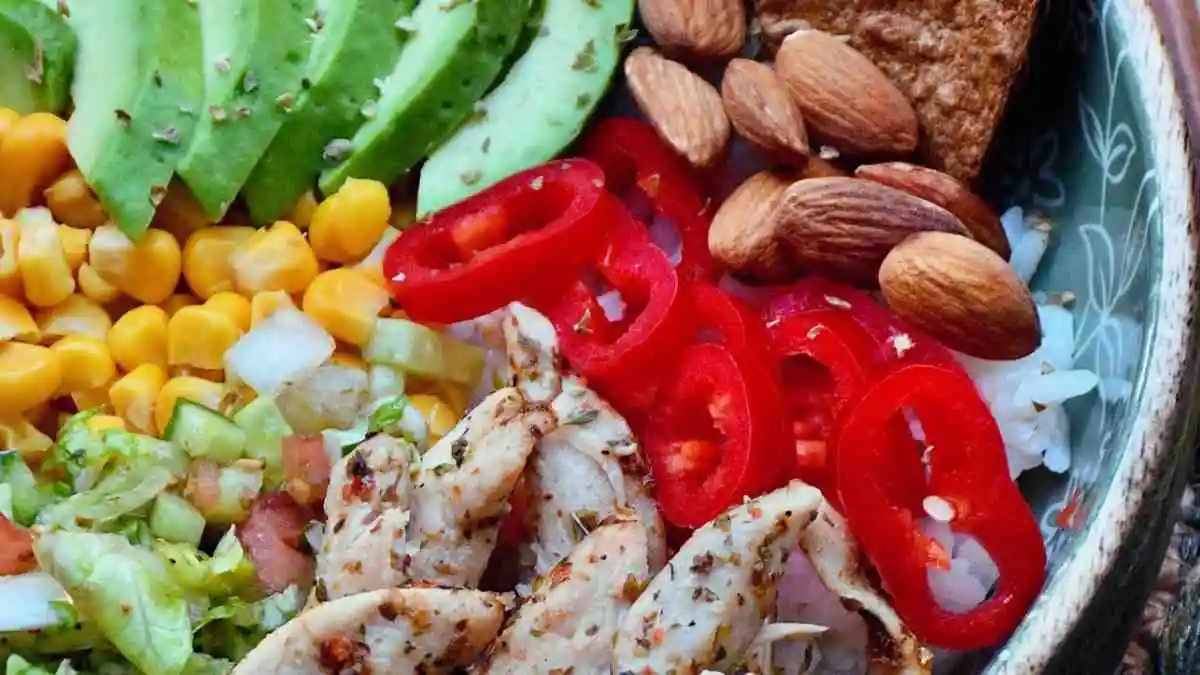 Grilled chicken avocado rice bowl with corn and fresh vegetables