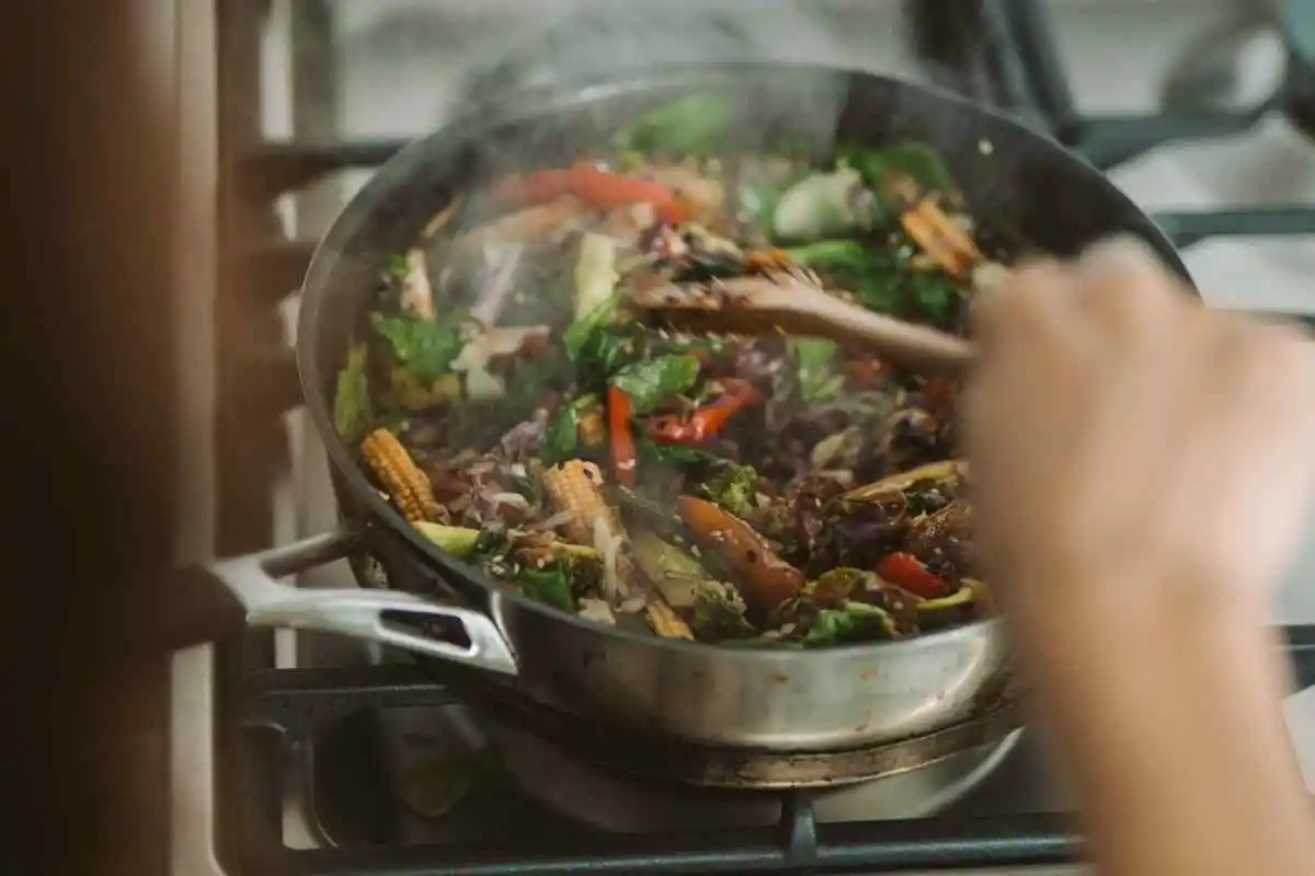 Cooking ground beef and broccoli slaw in a skillet on high heat