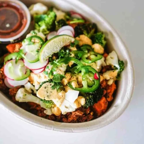 Southwest breakfast bowl topped with crunchy tortilla chips and fresh herbs