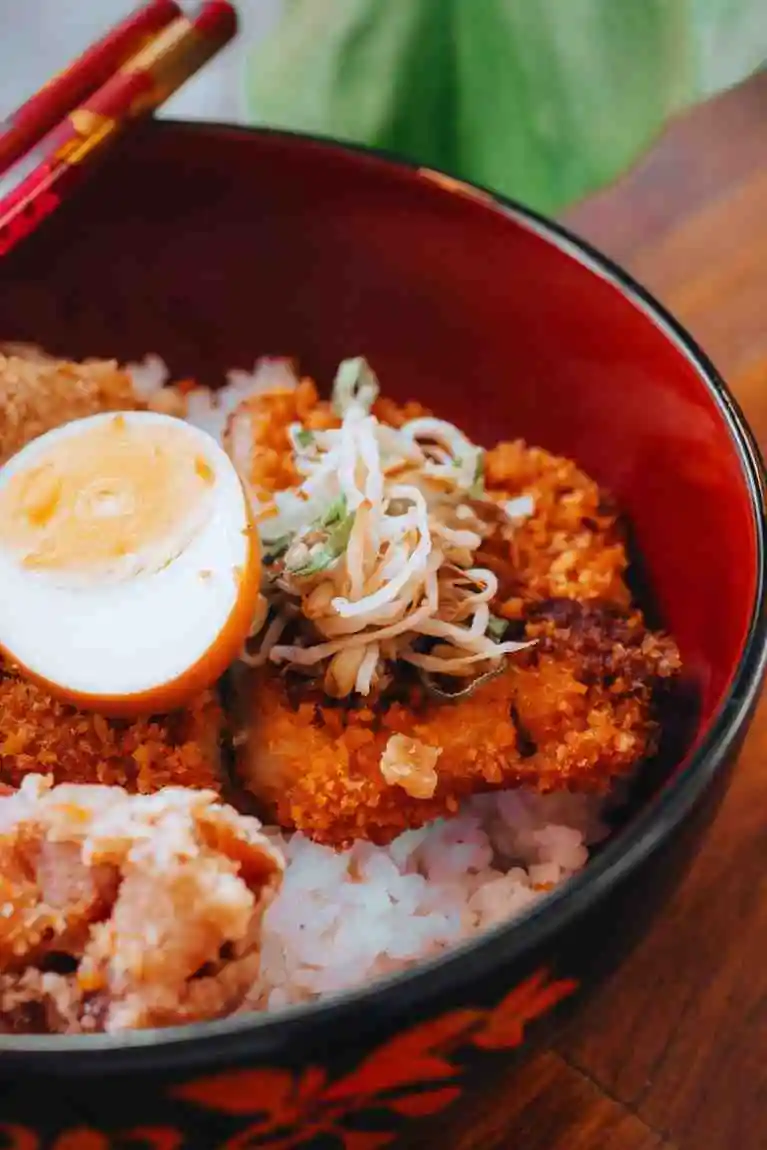 Close up of Japanese katsu bowl with ramen egg and rice