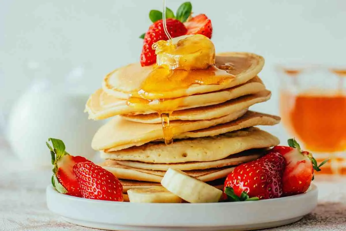Sweet pancake breakfast tacos topped with fresh strawberries blueberries and maple syrup
