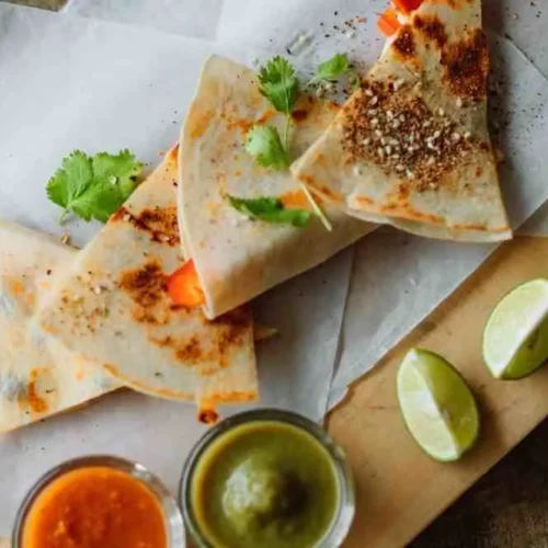 Ground beef quesadilla triangles served with salsa and guacamole dips