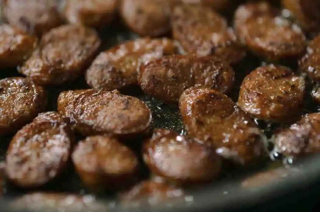 Slicing and browning Italian sausage in skillet
