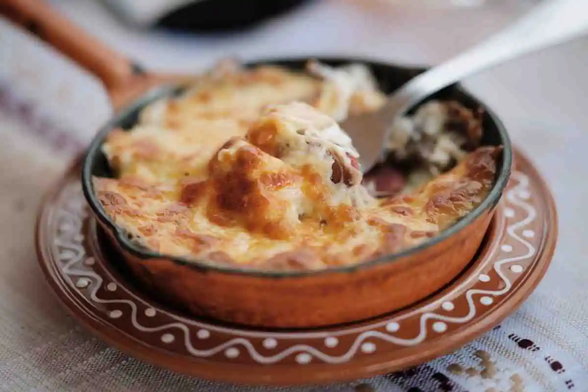 Freshly baked cheesy keto chicken casserole in a ceramic baking dish with melted golden cheese.