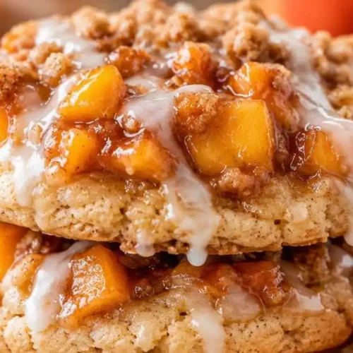 Stack of iced peach cobbler cookies made with cake mix and topped with diced peaches.
